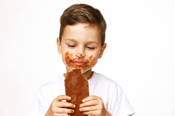 Cute young girl hyped up on too much sugar with chocolate ice cream all over her mouth.
