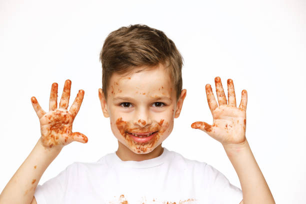 istock little boy with face and hands in chocolate 1137052497