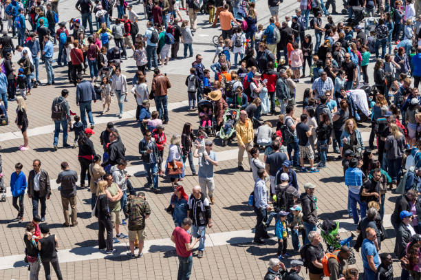 large group of people walking towards sunlight.