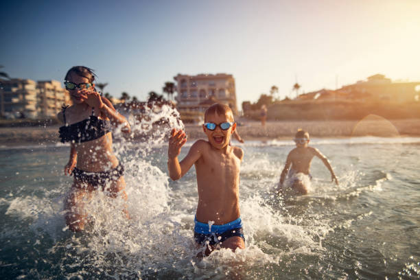 istock Kids having extreme fun running into sea 1137053337
