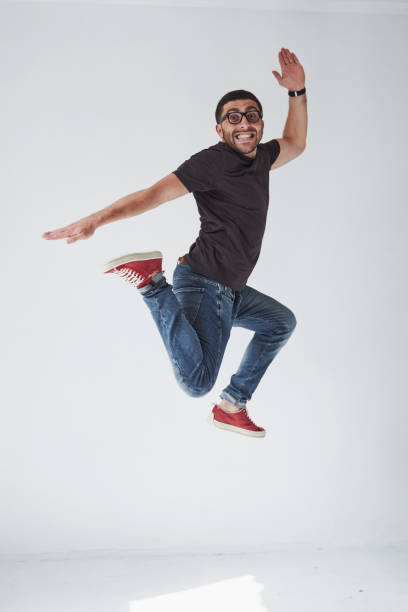 istock Image of cheerful young man casual dressed jumping over white background make different gesture 1137054253