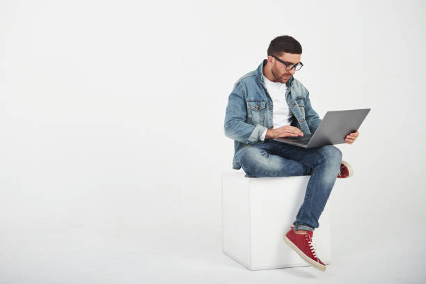 istock Handsome young man with laptop and check his timetable on white background 1137054356