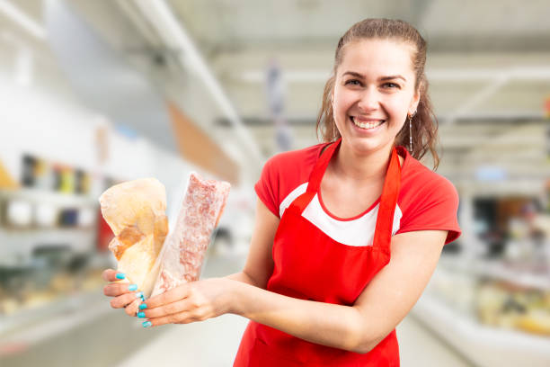 mulher que trabalha no supermercado que prende a carne congelada - supermarket meat store manager - fotografias e filmes do acervo
