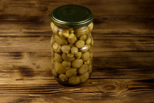 istock Delicious marinated mushrooms in glass jar on wooden table 1137060187
