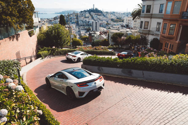 ロンバードストリートの頂上からの眺め、曲がりくねった通りを運転する高級車 - lombard street city urban scene city life ストックフォトと画像