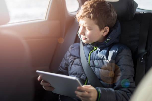 istock Little boy looking out from car window at sunny day. 1137060541