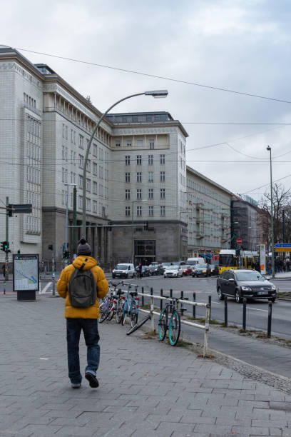 Berlin, Germany- December 12, 2018: man tourist walking down the Petersburger Str. in the district of Friedrichshain on a cloudy winter day
