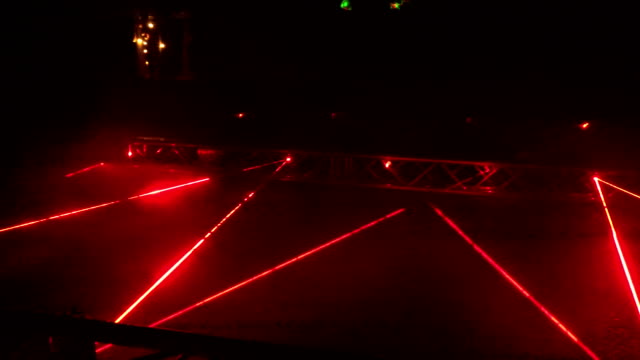 People walk laser formed red lines night light show. 4K