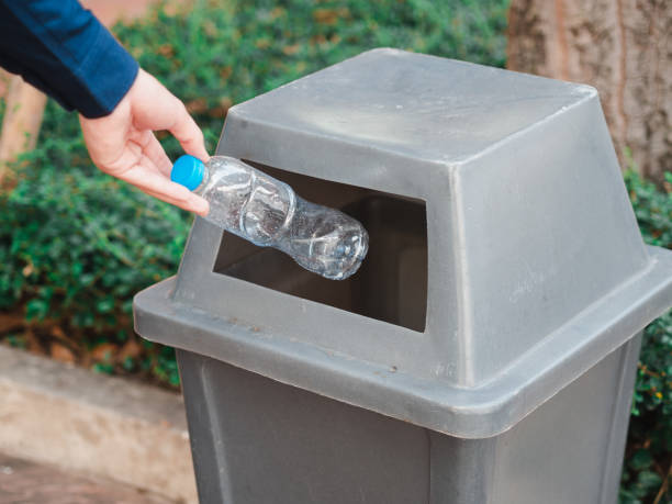 istock Closeup of man hand throwing empty plastic water bottle in a bin. 1137064103