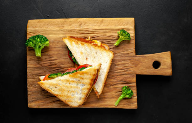 istock Broccoli cheese sandwiches on wooden cutting board, on concrete, slate background 1137064111