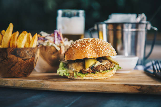 Classic beef burger served with french fries and coleslaw salad Tasty beef cheeseburger served with french fries, coleslaw salad and beer pub food stock pictures, royalty-free photos & images