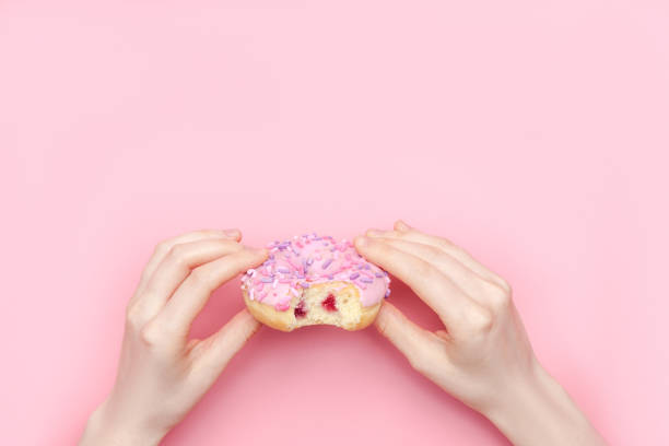 istock Donuts with icing on pastel pink background. Sweet donuts 1137066306