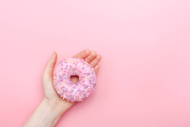 istock Donuts with icing on pastel pink background. Sweet donuts 1137066760