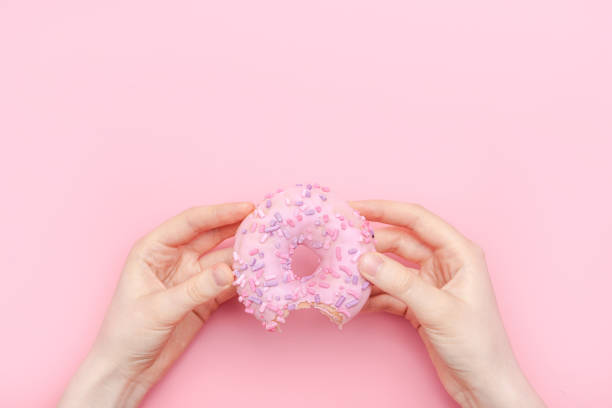 istock Donuts with icing on pastel pink background. Sweet donuts 1137067551
