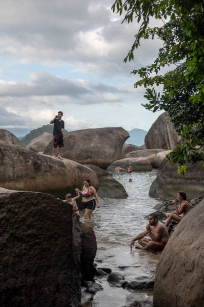 People enjoy the calm water at Cachadaço natural pool in Trindade, located near Paraty in the State of Rio de Janeiro, Brazil.