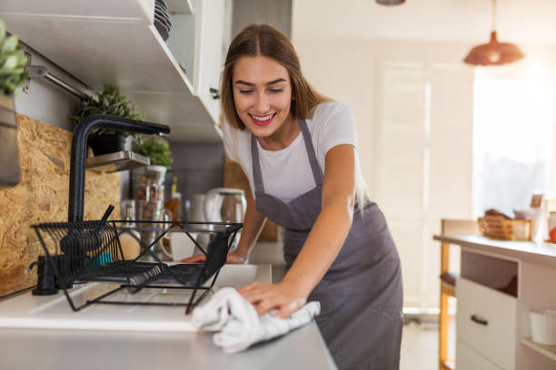 kobieta czyszczenie kuchnia licznik - domestic kitchen people fun lifestyles zdjęcia i obrazy z banku zdjęć
