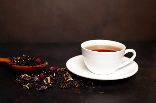 istock tasty tea in a white mug, scattered tea on a stone background 1137069423