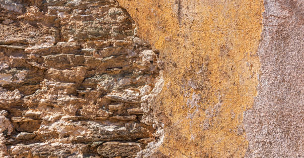 istock Old, distressed stone wall, building facade. Painted and faded, orange color masonry, texture background 1137069507