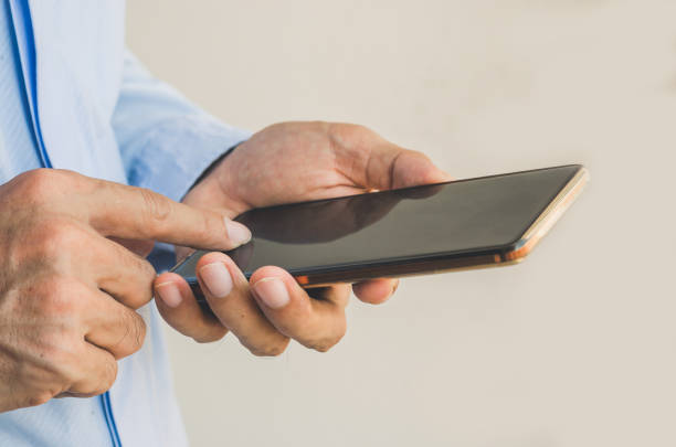 istock businessman using mobile phone touching screen in office with hands typing smart phone texting messaging lifestyle working app device technology internet social data online concept vintage style. 1137070144