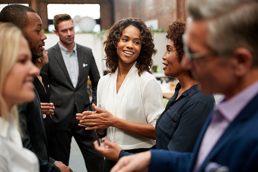 Business Team Standing Having Informal Meeting In Modern Office