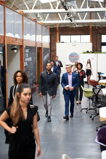 istock Businesspeople Arriving For Work In Busy Modern Open Plan Office 1137071732