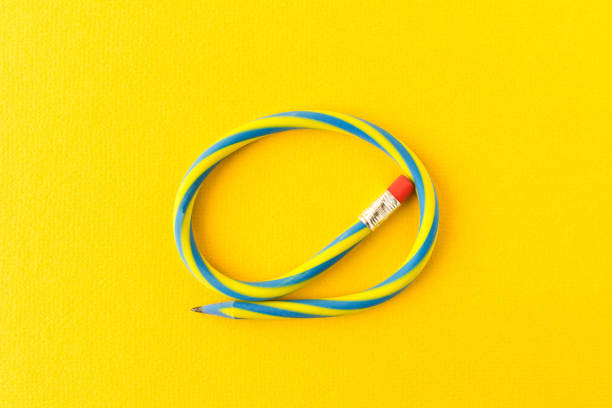 Flexible pencil . Isolated on yellow background. Bending pencil.