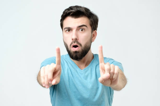 istock Experienced young man showing index fingers up, giving advice or recommendation 1137073006