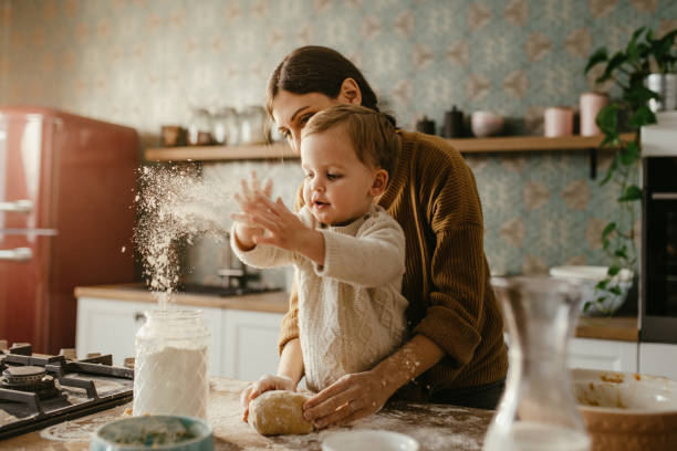 madre e figlio che fanno l'impasto - home baking foto e immagini stock