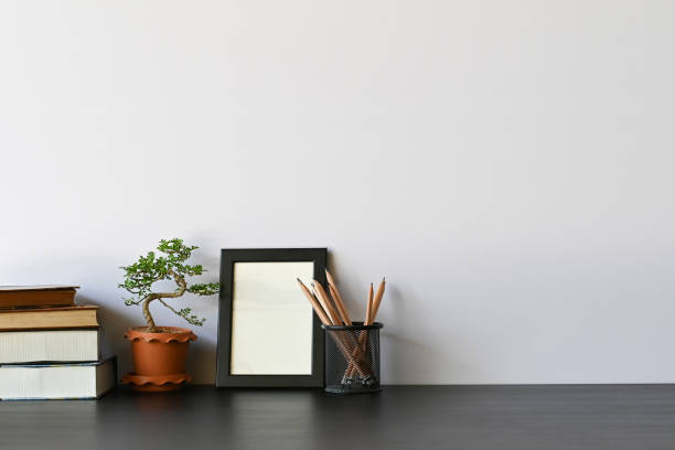 istock Workspace books, pencil, photo frame and bonsai on office desk. 1137073590