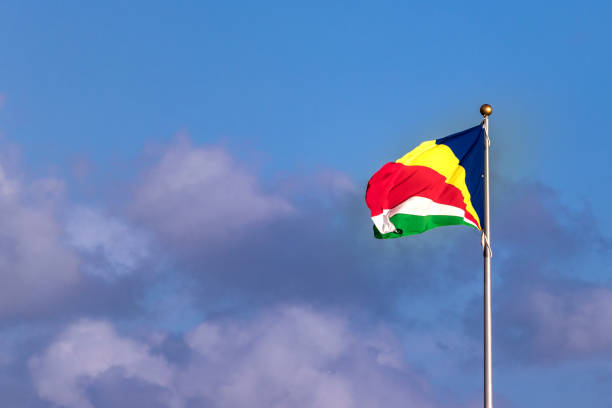 istock The flag of Seychelles over a blue sky with clouds 1137075294