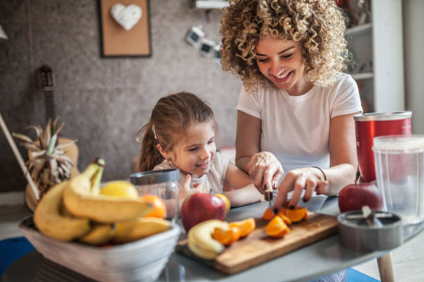 mother and daughter making  smoothie - breakfast family child healthy eating imagens e fotografias de stock