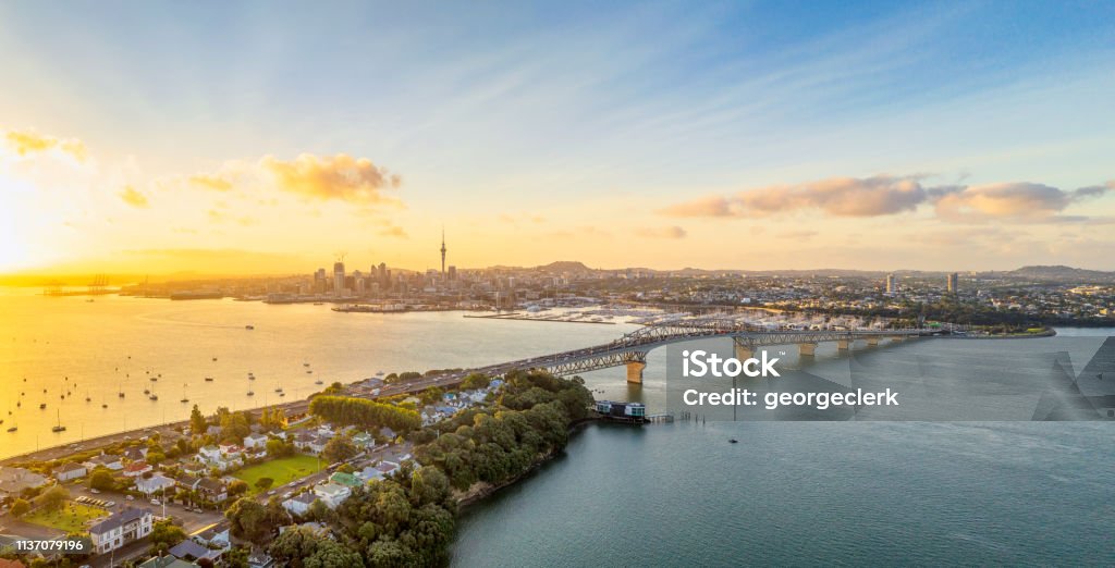 Auckland panorama at sunrise A panoramic image from above of Auckland, with the Sky Tower and CBD visible across Waitemata Harbor and the Auckland Harbour Bridge. Auckland Stock Photo