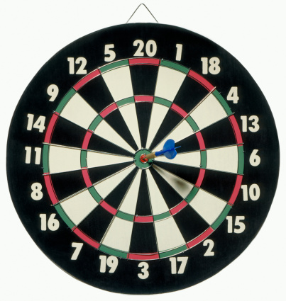The dart board has an arrow thrown into the center of the shooting target for business targeting.