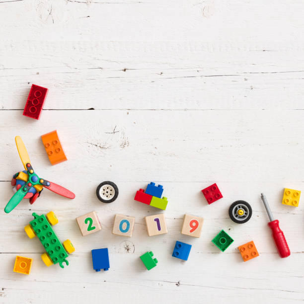 istock Multi-colored cubes, bricks and toys from plastic. Wooden cubes with numbers 2019 on a white wooden table. Early learning. Educational toys 1137083237
