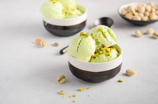 istock Pistachio ice cream in a bowls on a gray concrete background. 1137085418