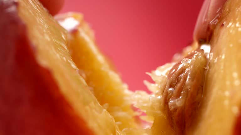 Ripe, juicy peach split in half. Extreme close up