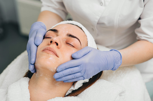 mujer que recibe tratamiento facial en salón de belleza. Exfoliación photo