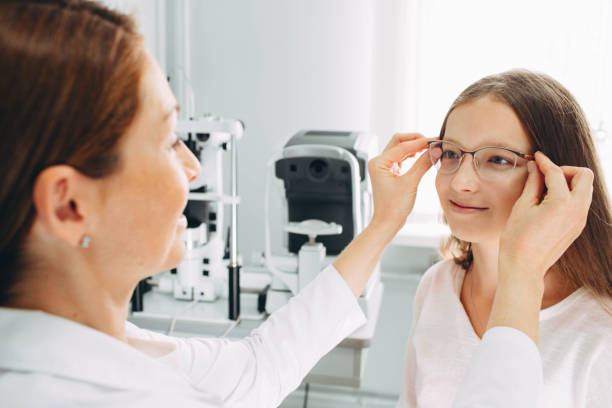 istock Optometrist is putting new glasses on girl face 1137094624