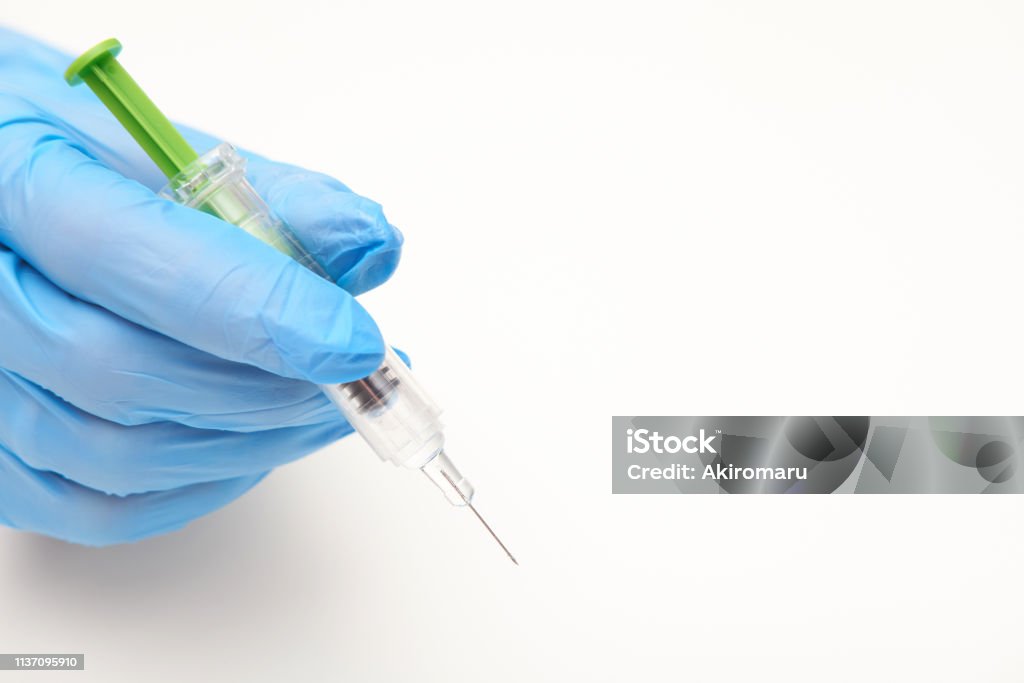 Hand in latex glove holding a syringe of anticoagulant, white background Anticoagulant Stock Photo