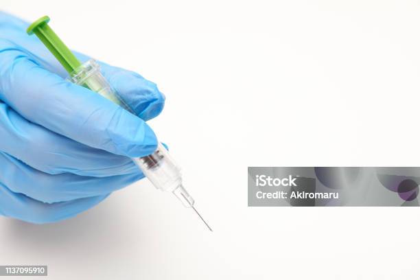 Hand In Latex Glove Holding A Syringe Of Anticoagulant White Background Stock Photo - Download Image Now
