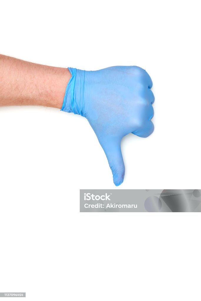 thumb in latex surgical glove showing dislike sign Adult Stock Photo