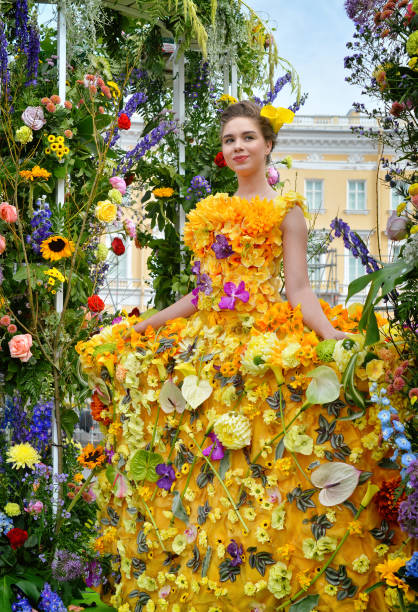 A young woman in a yellow dress adorned with flowers performs at the city day of Russia Day in St. Petersburg. Russia, St. Petersburg,June 11, 2018 - A young woman in a yellow dress adorned with flowers performs at the city day of Russia Day 11 June 2018 in St. Petersburg.The annual national holiday The Day of Russia is celebrated in the country since 1992 on a non-working day with entertainment events with the participation of various artists. pantomime dame stock pictures, royalty-free photos & images