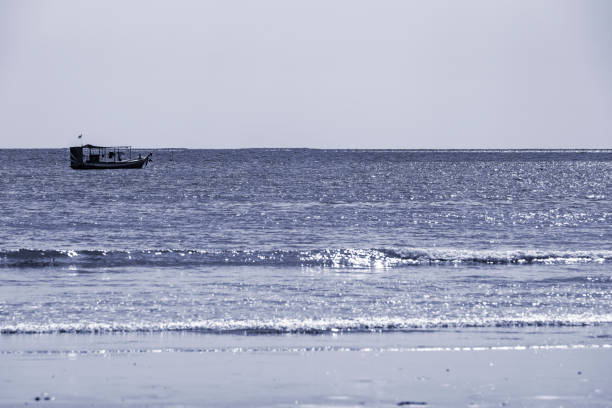 Longtail boat moored off the beach at Pakarang, Thailand. The image has been post processed to give a cool moonlit effect.