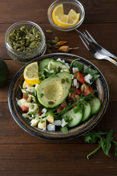 istock Healthy salad of fresh vegetables - tomatoes, avocado, arugula, egg, spinach. Flat lay. Top view. 1137098381