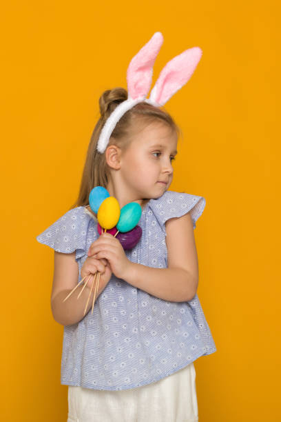 istock cute little girl with Easter bunny ears holding colorful eggs 1137100850