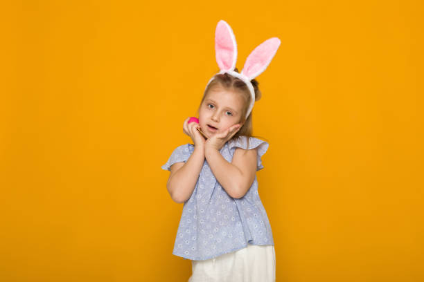 istock cute little girl with Easter bunny ears holding colorful eggs 1137100903