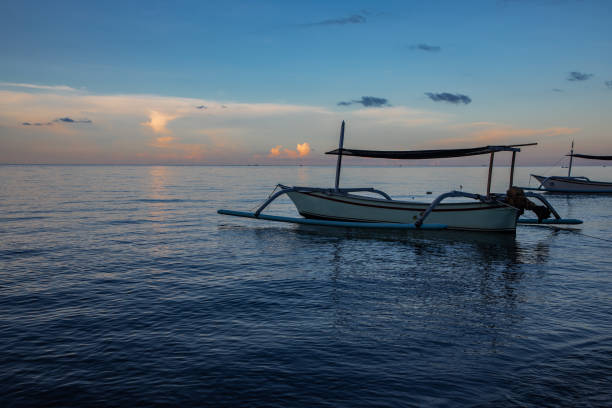 istock Blue hour over calm ocean and black sand beach with balinese boat 1137103793