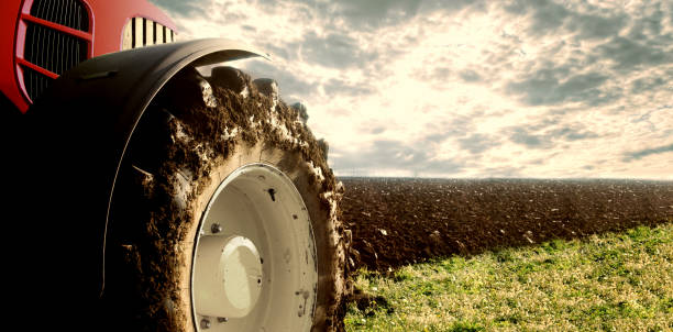agricoltura. campo di aratura del trattore. ruote ricoperte di fango, campo sullo sfondo. campo coltivato. agronomia, agricoltura, concetto di allevamento. - tillage foto e immagini stock