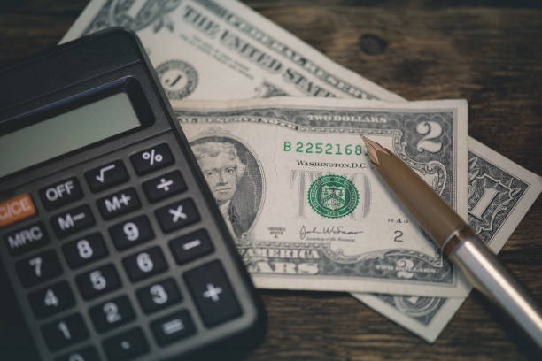 Calculator and a few dollars on a table.. Tight of money. Lack of money. Financial problems. Bankrupt. Pay the debts concept.