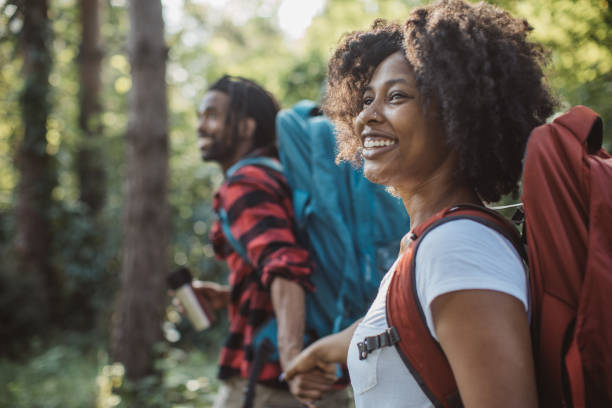 Hor drink on forest walk Young couple on vacation in countryside, they enjoy in summer. They walking through forest, exploring nature and drinking hot coffe from travel mug couple adventure activity adult stock pictures, royalty-free photos & images